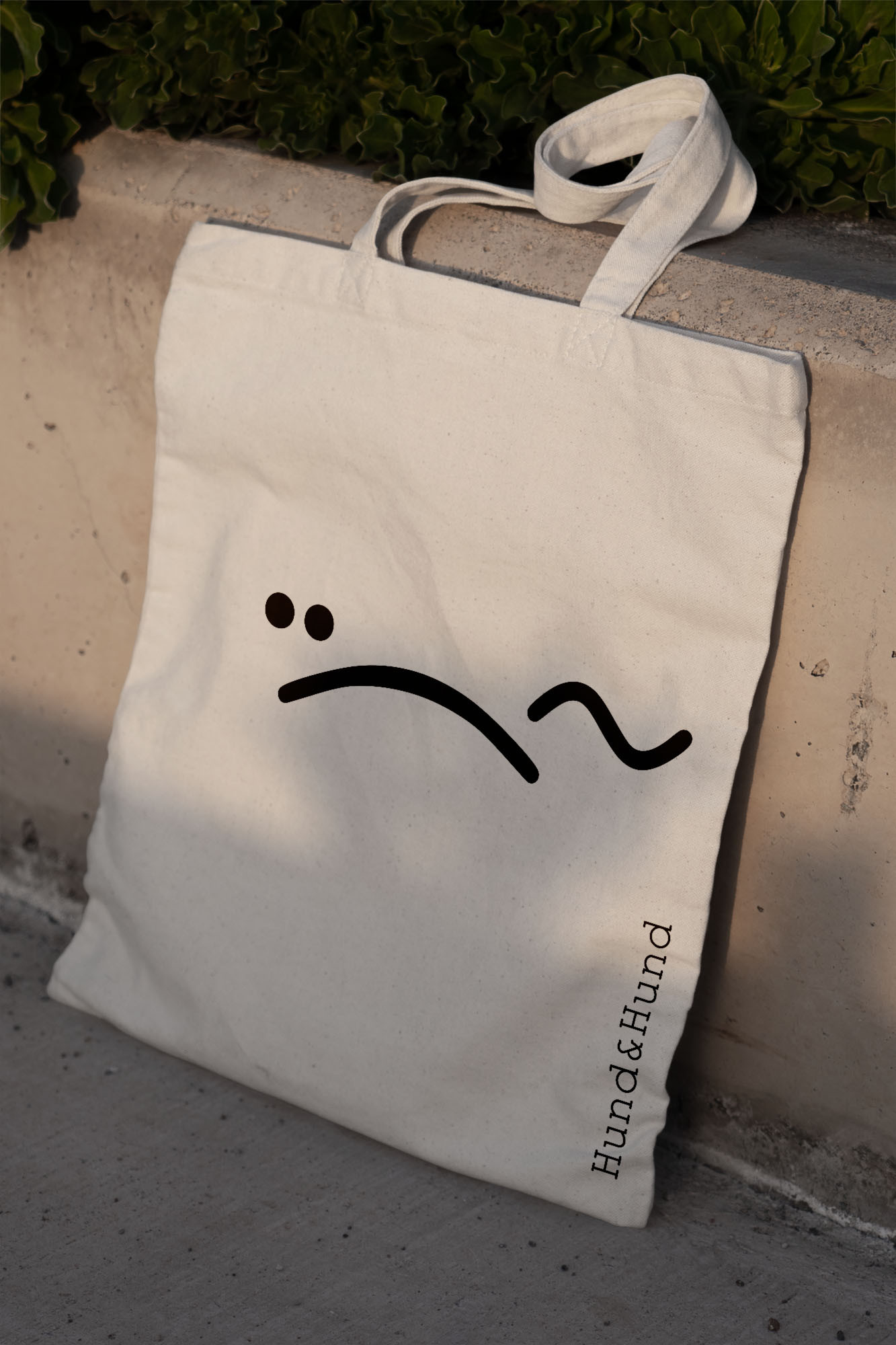 Hund & Hund logo on a tote bag leaning against wall by BusbyWebb